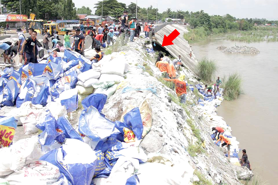 THE BAYANIHAN SPIRIT AMONG US – As proof that the Taraqueños are resilient and could rise up against the challenge, volunteers from different barangays, business sector, and government agencies, in bayanihan, all pooled their resources to undertake a proactive sandbagging project along Romulo Blvd. Photo on top shows an obvious substandard project that was said to have been completed a year ago. Mayor Angeles said that DPWH will be the agency to undertake the long-term solution to the problem./Photos from FB/Mayor CristyAngeles